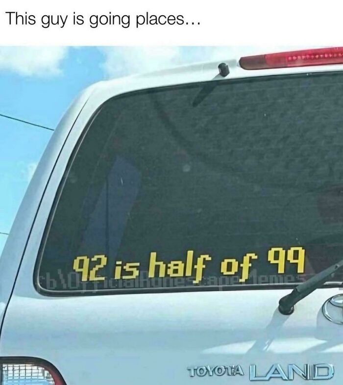 A funny bumper sticker on a car's rear window says '42 is half of 99,' requiring someone to explain the joke.