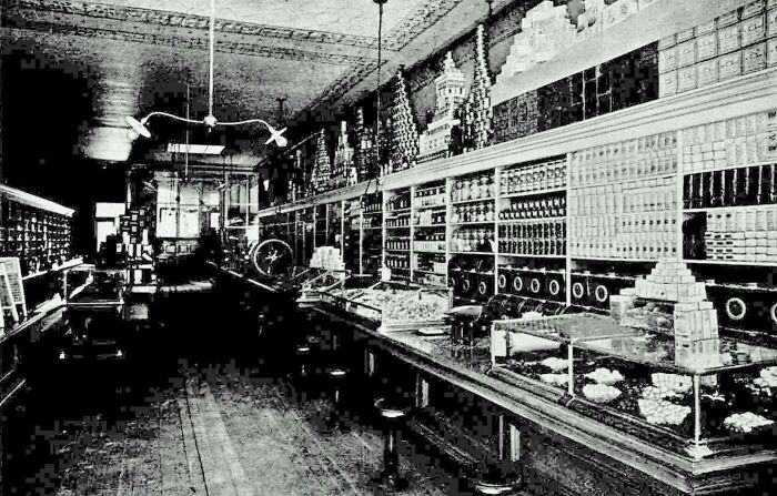 Victorian era photos showing an interior of a vintage candy or general store with shelves stacked high and display cases.