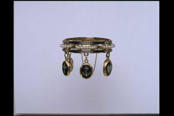 Victorian era bracelet with pearl and gold charms, showcasing period jewelry design and craftsmanship.