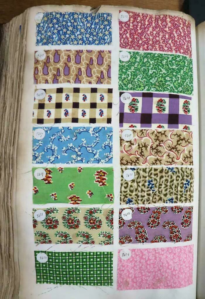 Victorian era fabric swatches with floral and geometric patterns displayed in a vintage textile sample book.