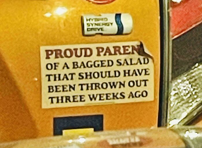 Funny bumper sticker on yellow car about being a proud parent of a bagged salad