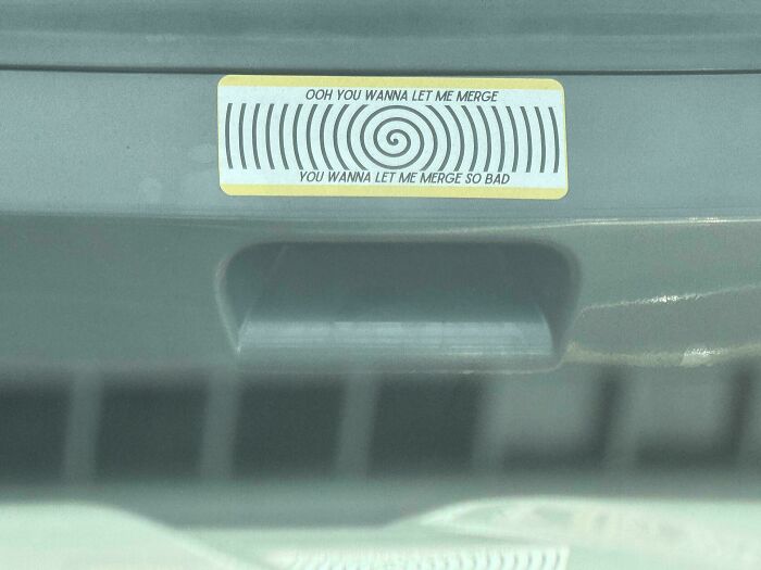 Bumper sticker with text about merging on car rear