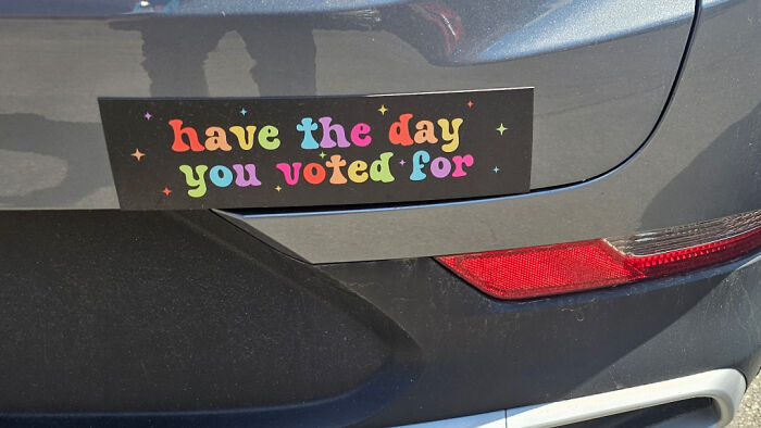 Colorful bumper sticker saying have the day you voted for on car trunk
