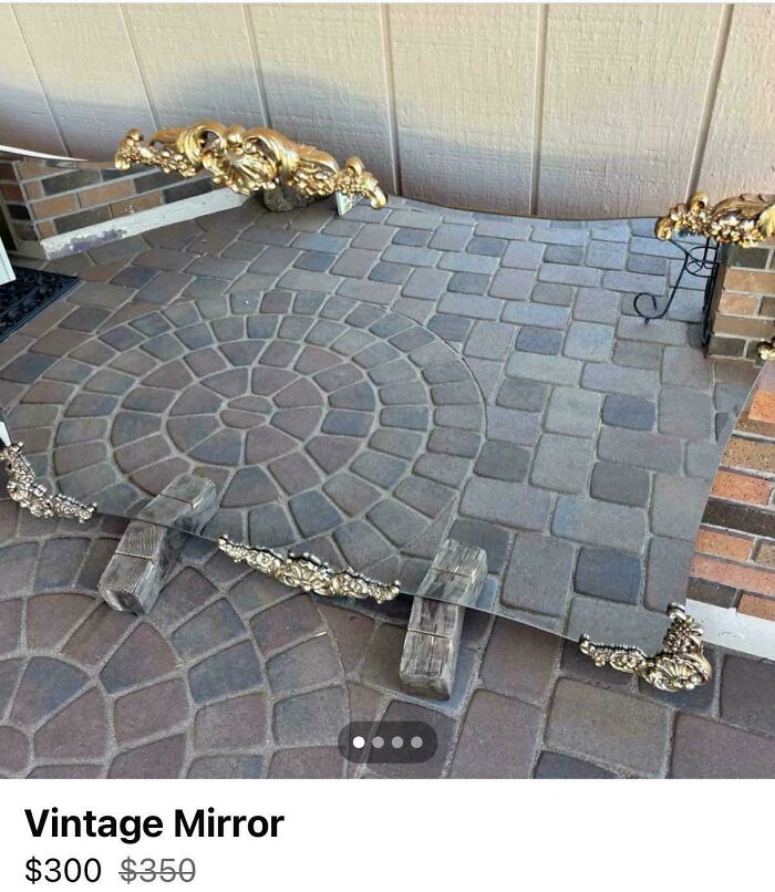 Antique mirror reflecting a patterned stone floor, creating a misleading and confusing photo that looks like a real-life glitch.