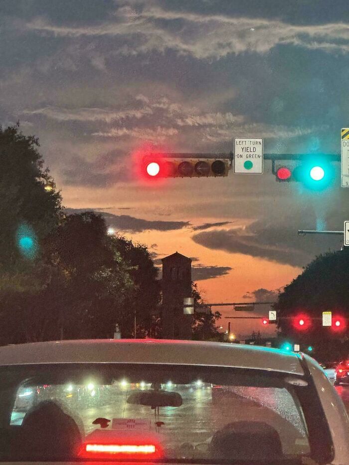 Traffic lights showing red and green simultaneously at dusk, a misleading photo that seems like a glitch in real life.