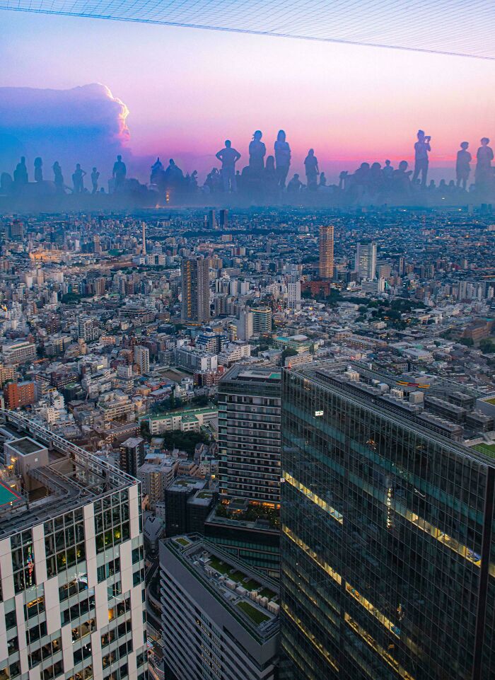 City skyline at sunset with silhouettes of people appearing like a glitch in real life, creating a misleading and confusing photo.