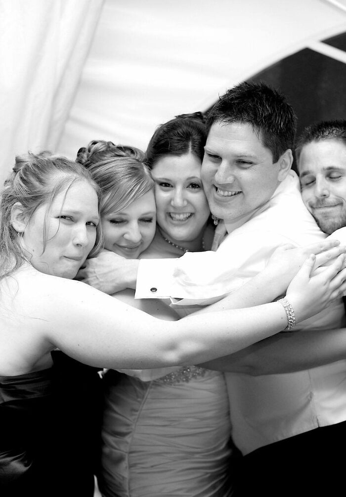 Group of people in a close hug at an event creating a misleading and confusing photo that seems like a glitch in real life