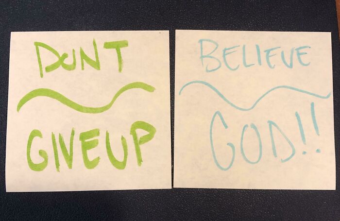 Two handwritten signs on paper saying Dont Give Up and Believe God with quirky lettering, comedic gold signs.
