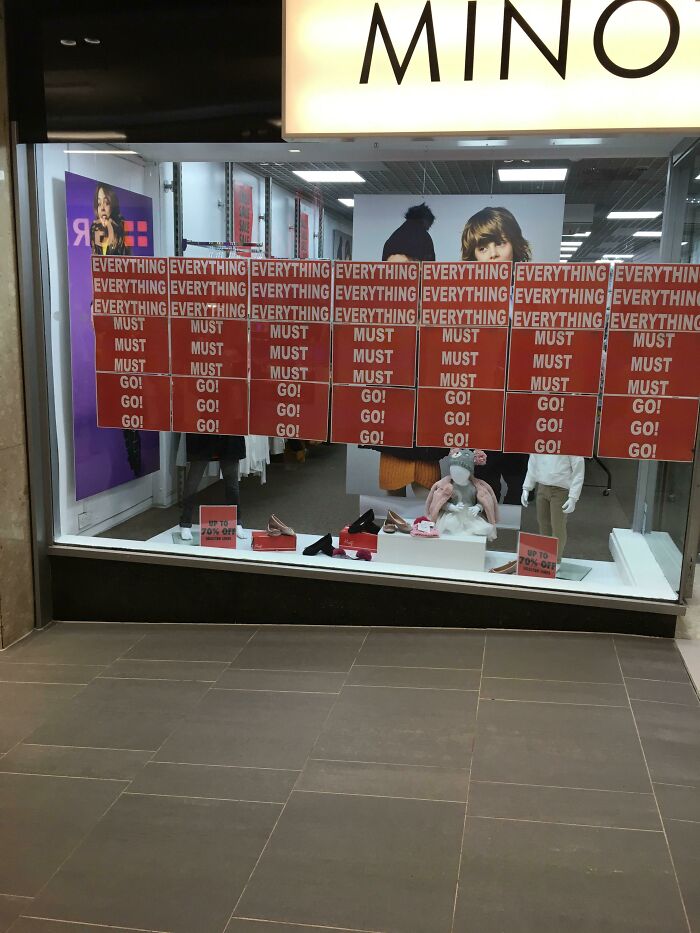Store window filled with confusing sale signs reading everything must go, a comedic sign fail from signs that went wrong.