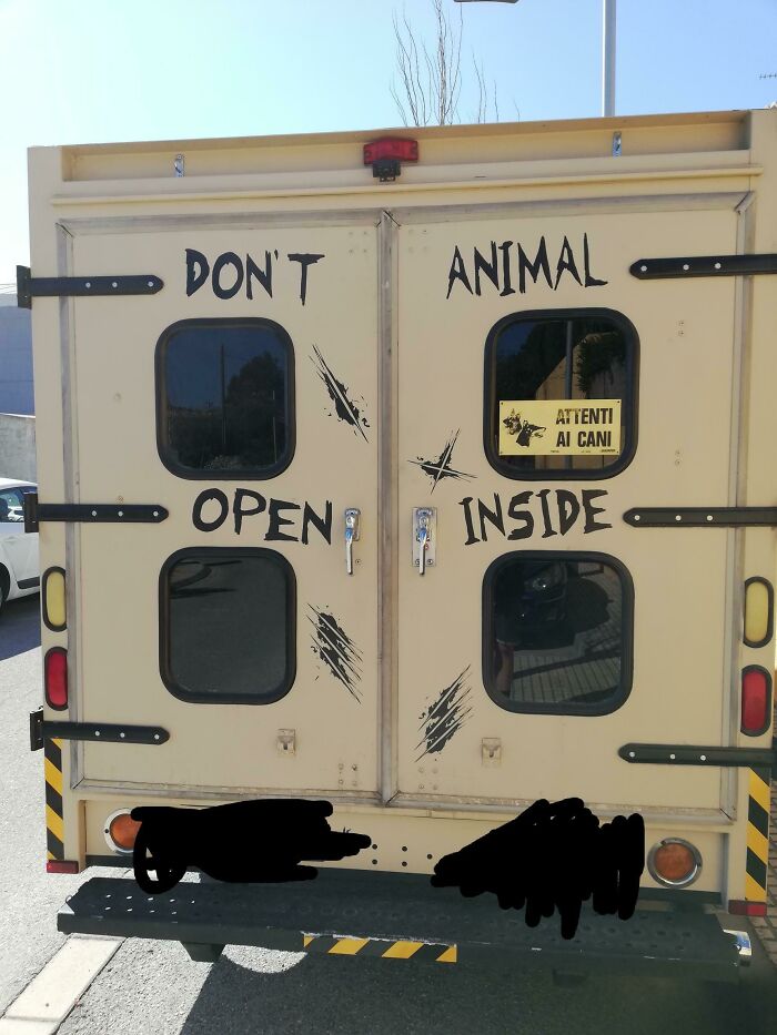 Humorous sign on a vehicle stating don’t open animal inside, a comedic sign fail turning into comedic gold.