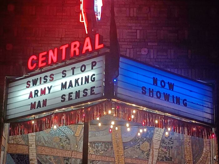 Theater sign with comedic gold words saying Swiss stop army making man sense at night.