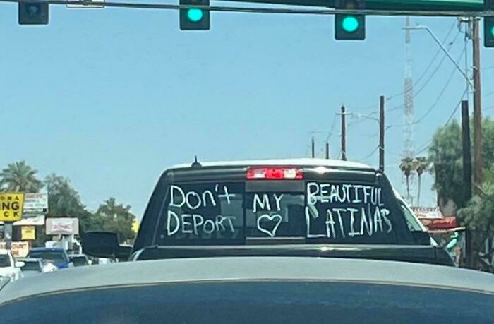 Pickup truck with a sign on the back window showing a comedic wrong sign about deporting beautiful Latinas.