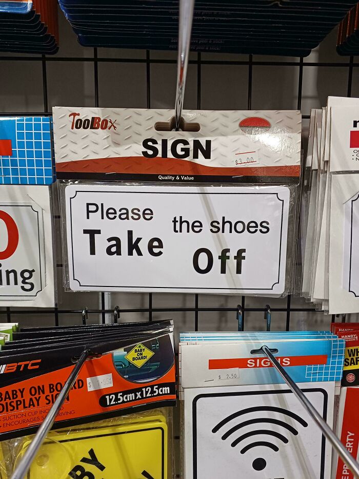 Humorous sign with misplaced words reading Please Take the shoes Off at retail display, example of signs gone wrong.