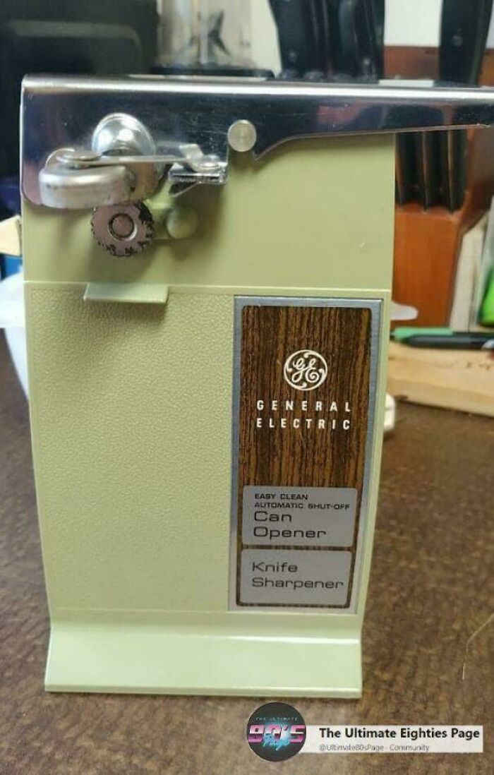A vintage General Electric electric can opener, light green with a wood-look panel. This image takes you way back.