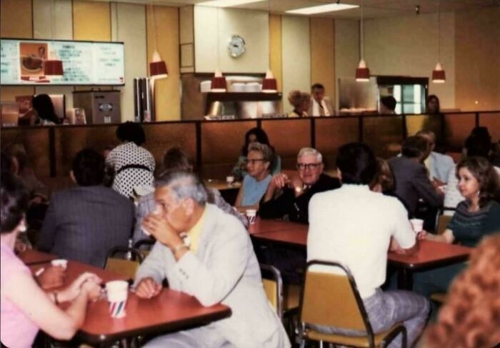 A bustling retro diner scene with customers enjoying meals, reminding you how old some places look.