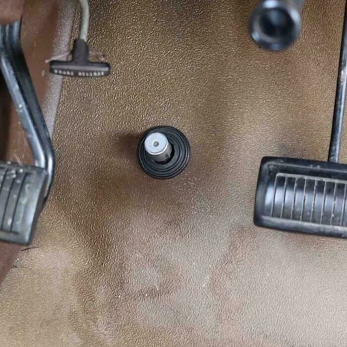 A close-up of a car floor with a high beam dimmer switch, a nostalgic image that might take you way back.