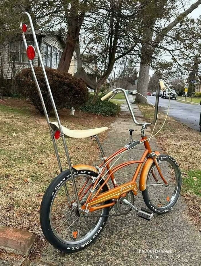 An orange vintage Schwinn Sting-Ray bicycle with high handlebars and a banana seat, for images that take you way back.