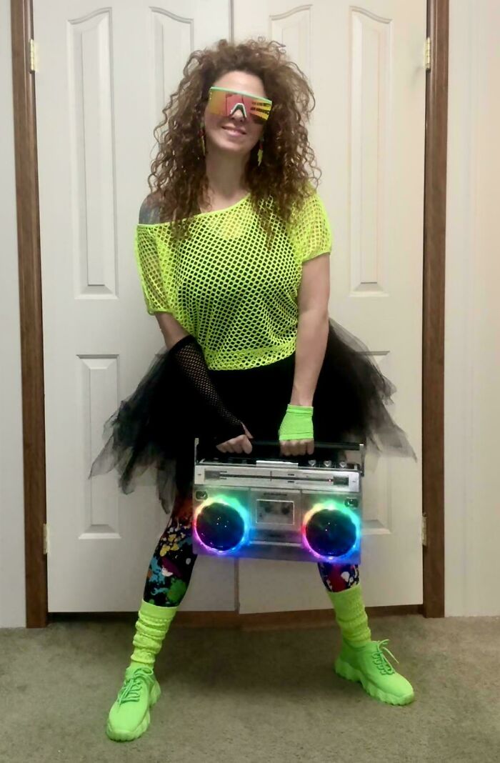 Woman dressed in neon 80s fashion holding a light-up boombox, embodying nostalgic and relatable Gen X style.