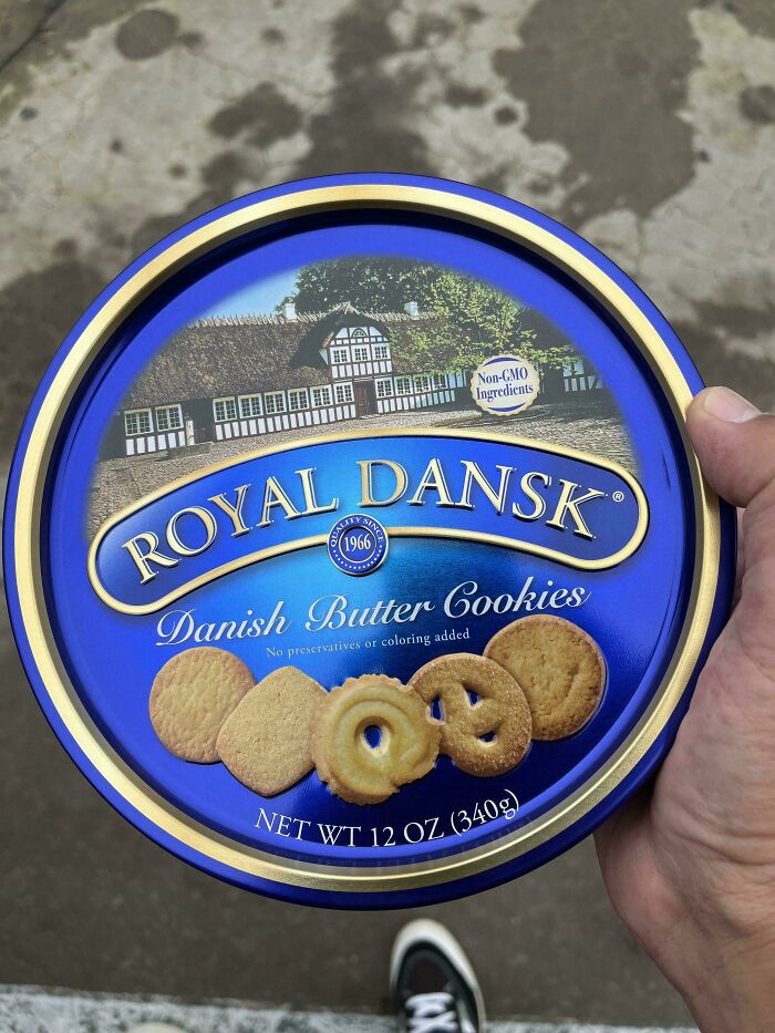 Hand holding a blue tin of Royal Dansk Danish butter cookies, a nostalgic treat familiar to Gen X generations.