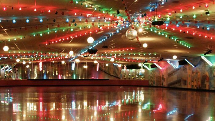 Retro roller skating rink with colorful string lights reflecting on polished wooden floor, evoking nostalgic Gen X memories.
