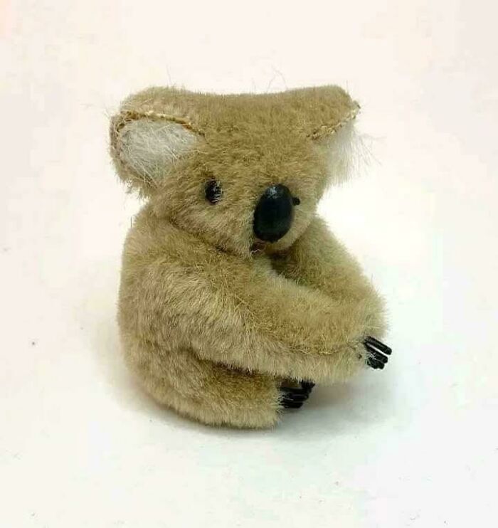 Small vintage plush koala toy sitting with arms wrapped around knees, evoking nostalgic and relatable Gen X memories.