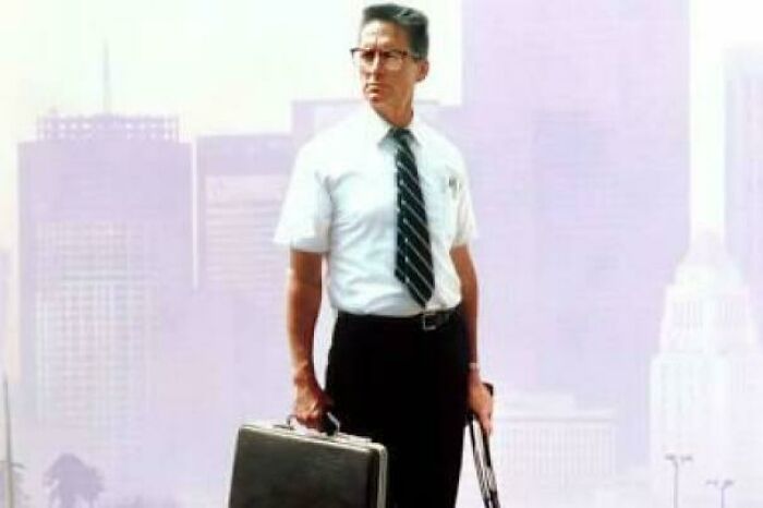 Man in retro office attire holding briefcase and umbrella, evoking nostalgic and relatable Gen X vibes.