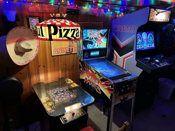 Retro arcade games and vintage pizza parlor decor lit by colorful string lights, evoking nostalgic Gen X memories.