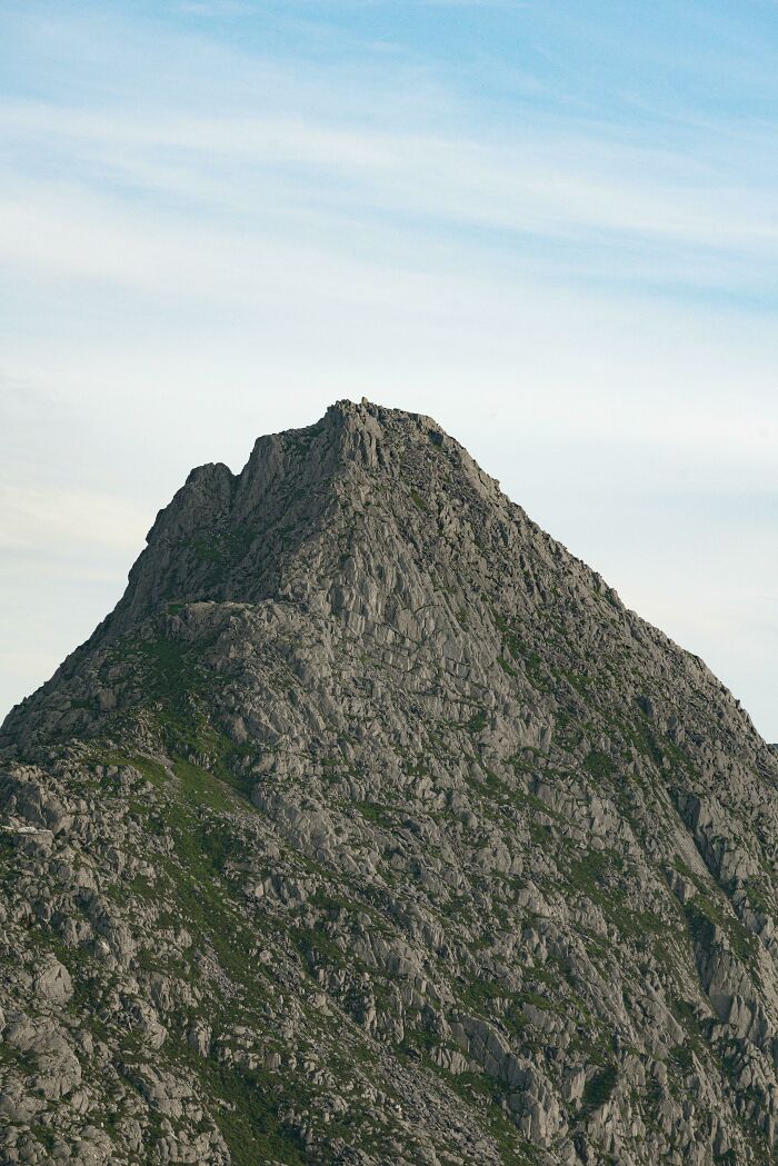 Rocky mountain peak blending with surrounding terrain in a perfectly camouflaged natural landscape under blue sky