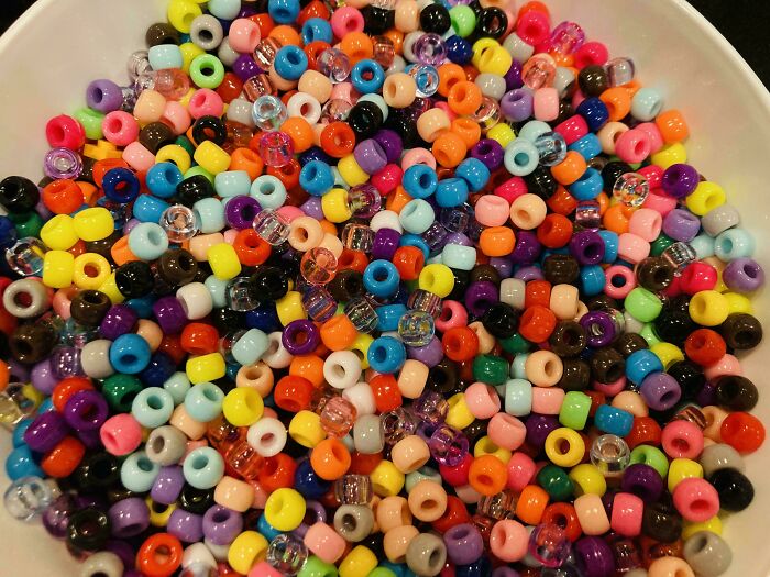 Colorful small beads tightly packed in a bowl, blending together in a scene of perfectly camouflaged things to find.