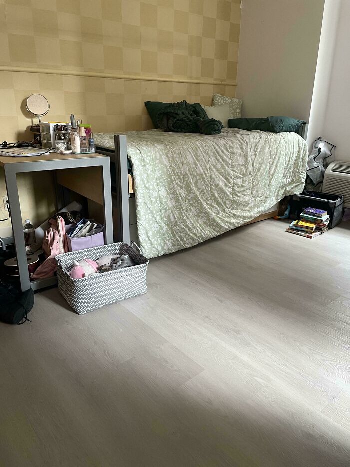 A perfectly camouflaged cat blending with the blanket on a bed in a cozy bedroom setting.