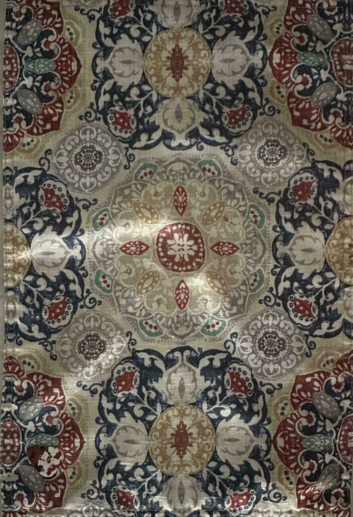 Intricate patterned fabric with perfectly camouflaged insect blending into the detailed floral design background