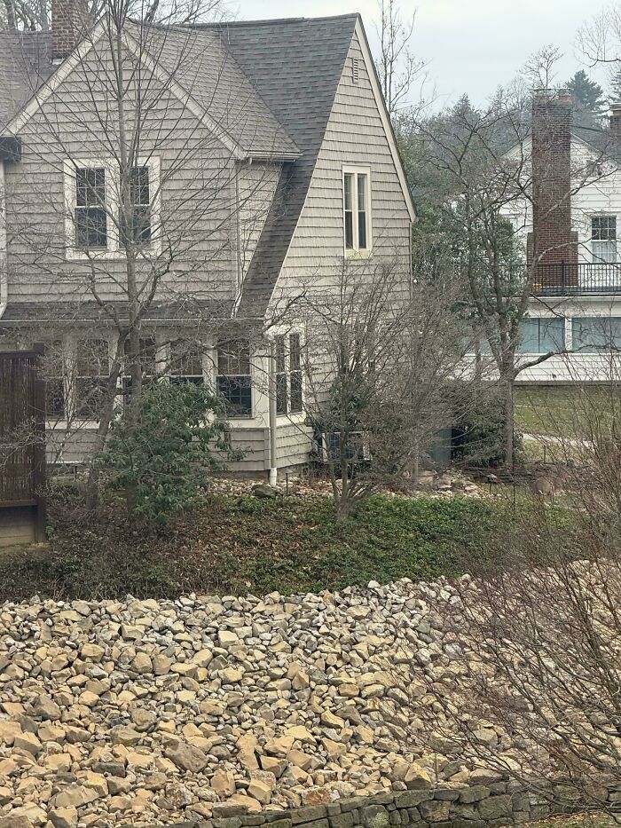 House with beige siding blending into surrounding trees and rocks, showcasing perfectly camouflaged things hard to find.