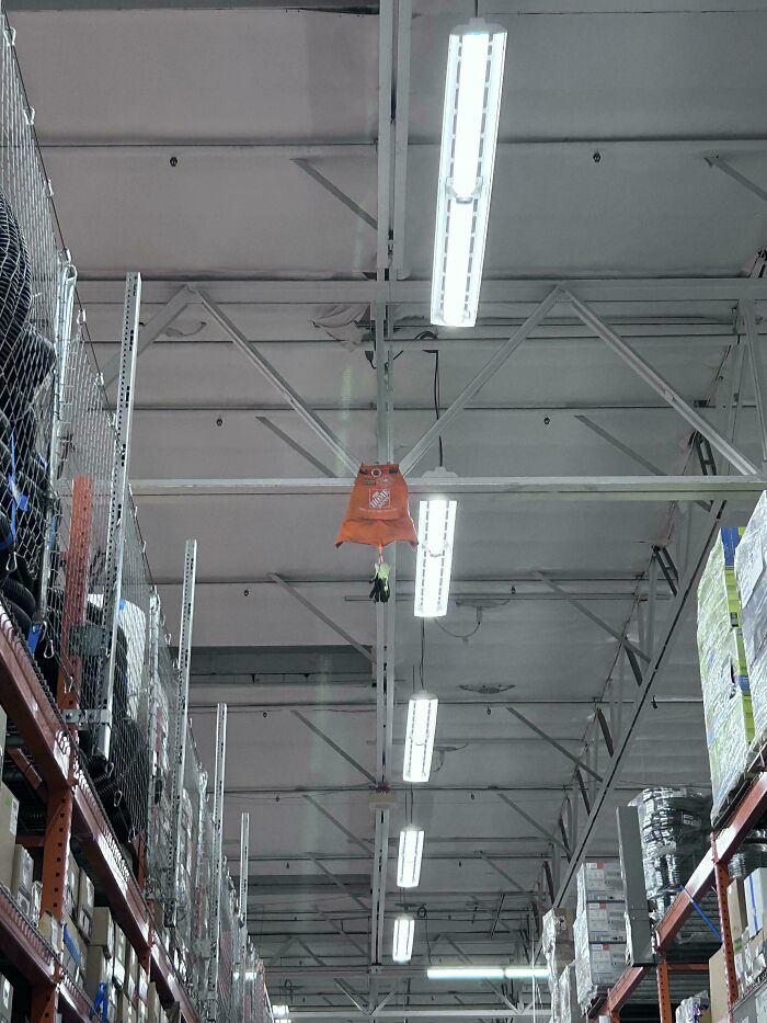 Home Depot apron hanging high from the ceiling structure inside a store aisle