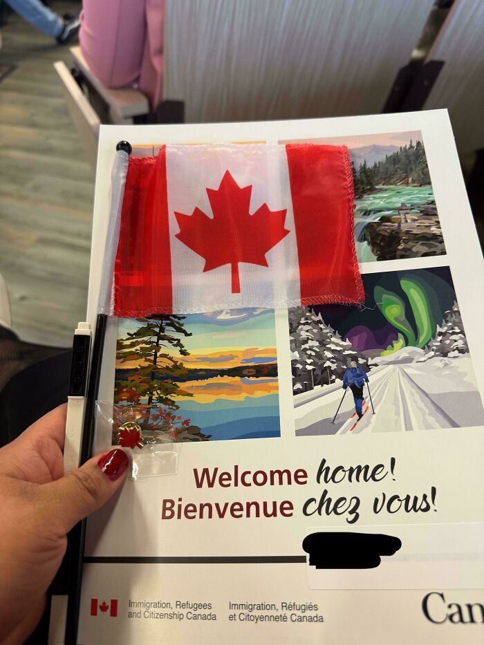 Hand holding Canadian flag and welcome home guide for immigration refugees