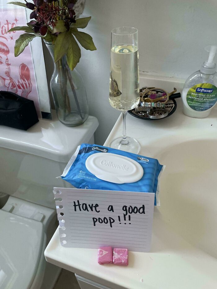 Bathroom counter with champagne glass and note saying have a good p**p
