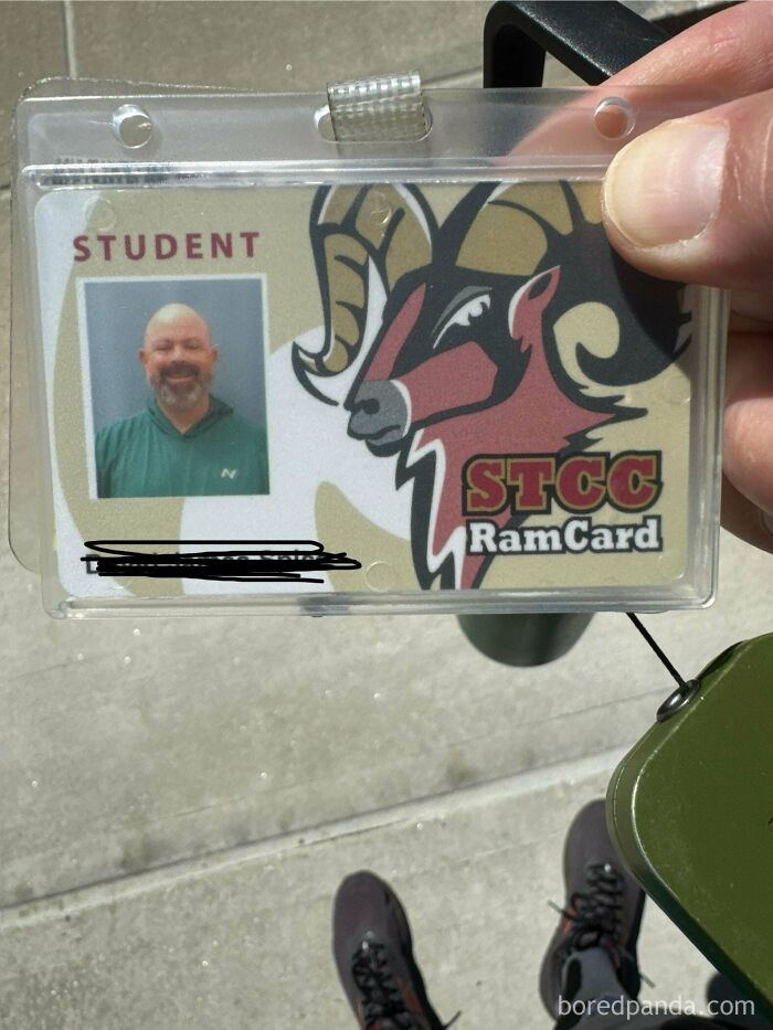 Student holding STCC RamCard with smile feeling warm and fuzzy on campus