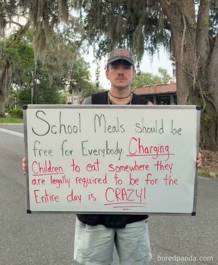 Man holding sign advocating free school meals for all children