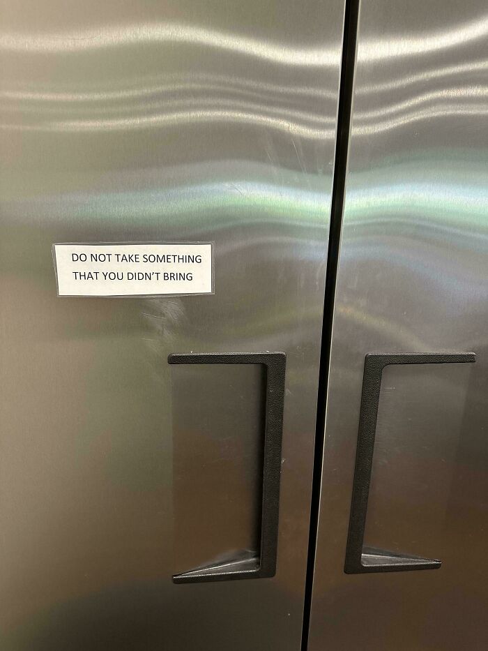 A passive-aggressive note on a stainless steel fridge door. It reads: DO NOT TAKE SOMETHING THAT YOU DIDN'T BRING.