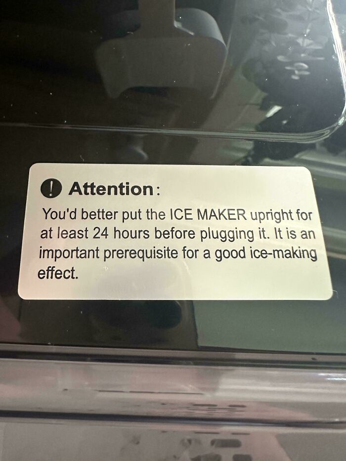 A passive-aggressive note on an ice maker instructing to keep it upright for 24 hours.