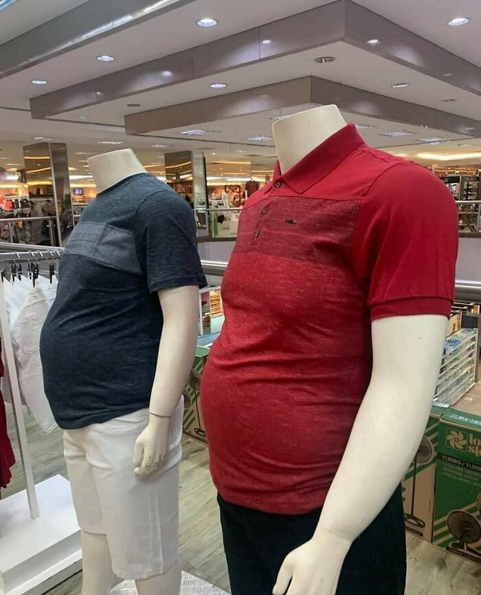 Two headless mannequins with unusual, exaggerated belly shapes wearing casual t-shirts in a store display.
