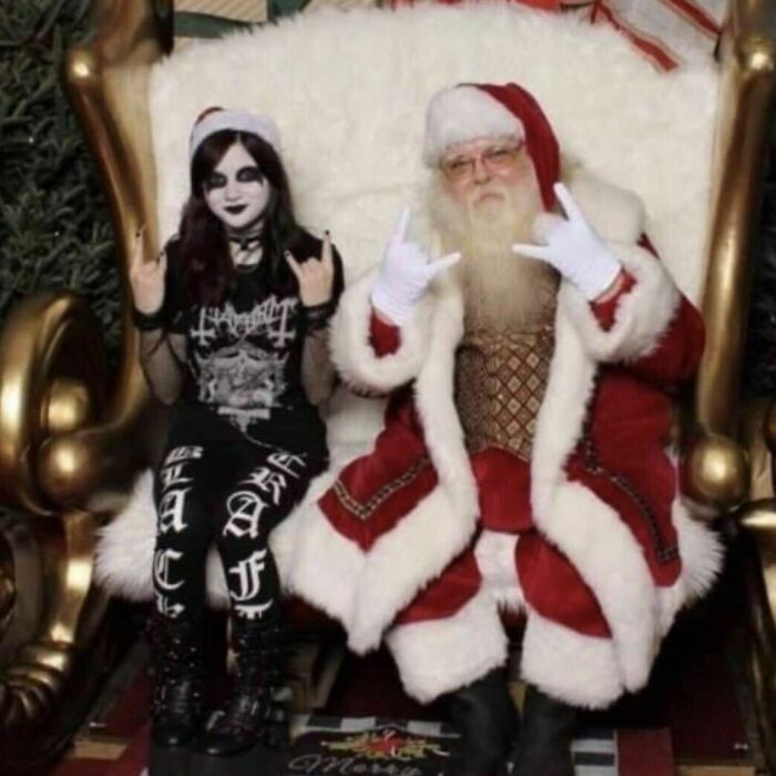 Santa Claus and gothic girl making rock hand signs on a large throne in a weird and confusing cursed image