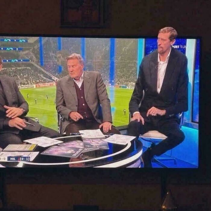 Sports commentators on a TV show with one person appearing unusually tall in a weird, confusing, and cursed image.