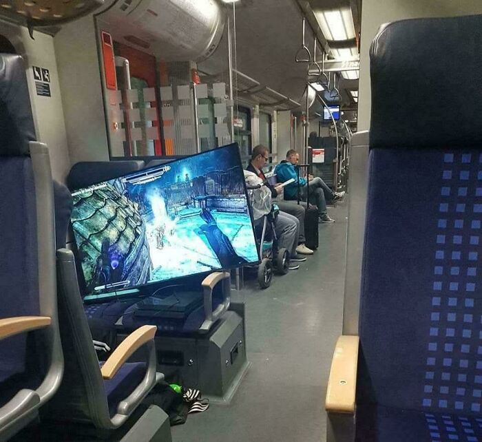 Gaming screen mounted inside a train carriage creating a weird and confusing scene for passengers.