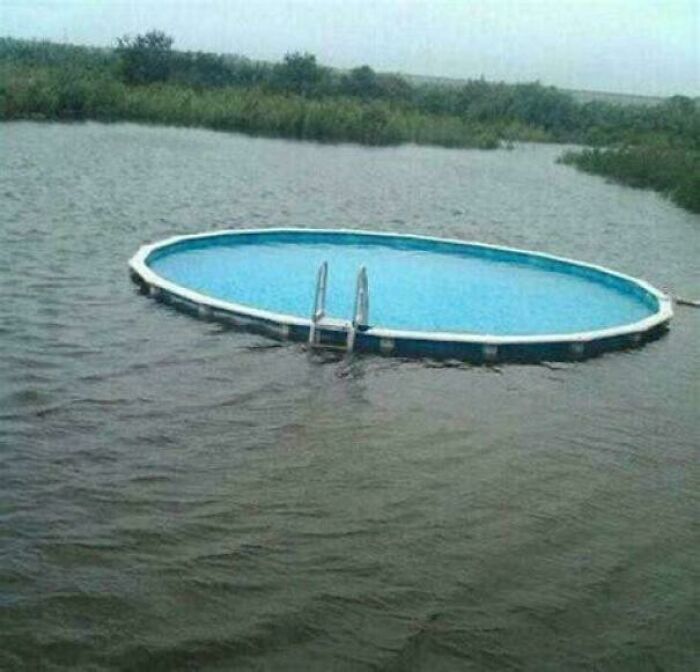 Above-ground swimming pool floating in a flooded area, creating a weird, confusing, and cursed visual effect.