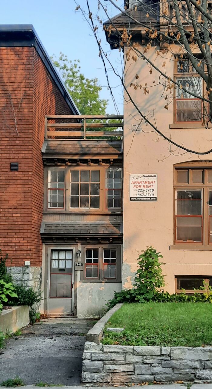 Narrow small apartment building with for rent sign between larger structures