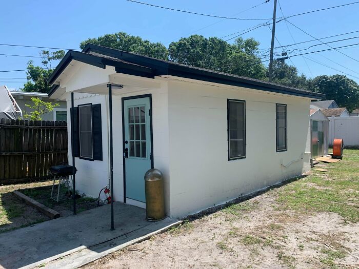 Cozy small home with light blue door in backyard
