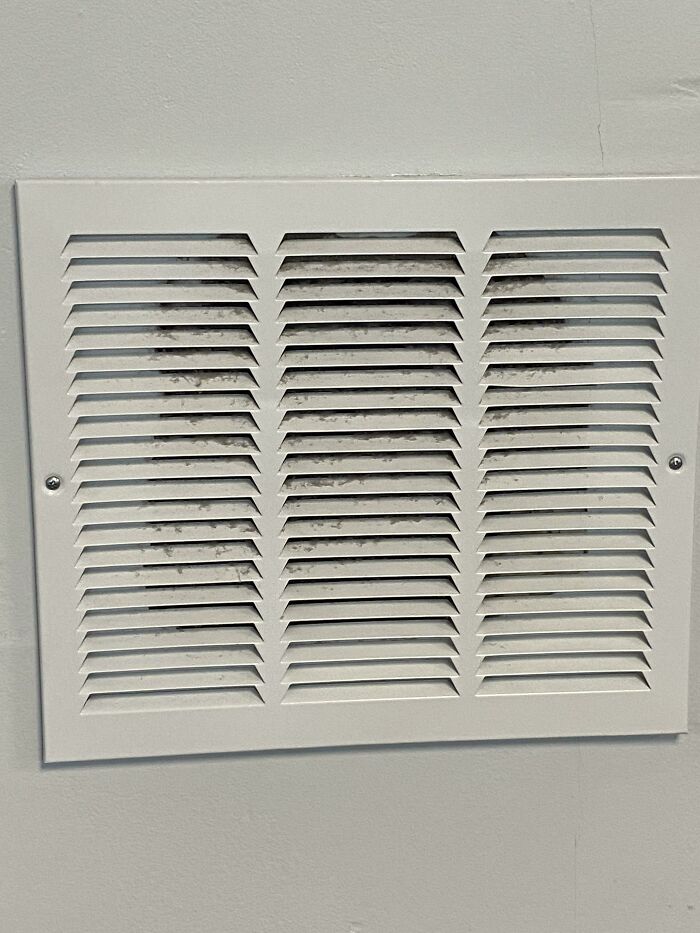 Air vent with black marks behind the grill, showcasing a technically works but dumb solution to a ventilation problem.