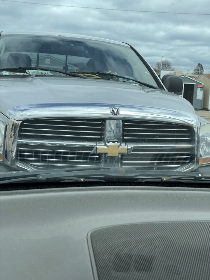Car with a mismatched Chevrolet emblem humorously demonstrating a technically works but dumb solution to a problem.