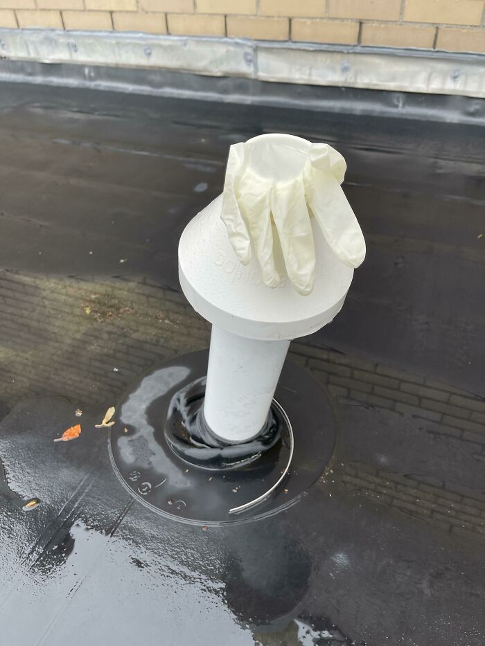 White glove placed over a rooftop vent pipe as a technically works but dumb solution to block something.