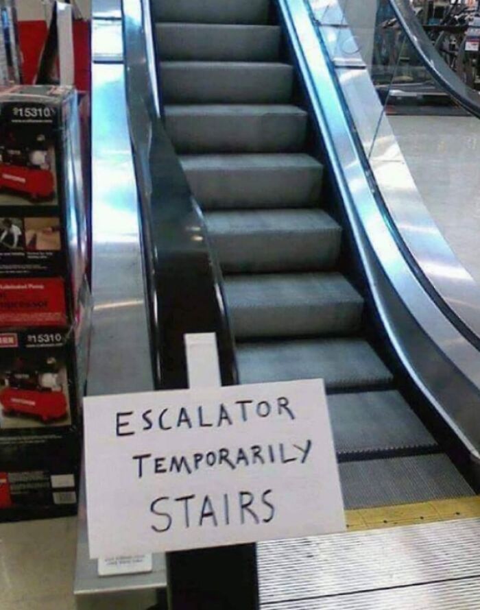 Escalator temporarily used as stairs with a handwritten sign, a technically works solution to a broken escalator problem.